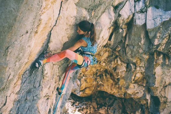 Una chica sube una roca . —  Fotos de Stock