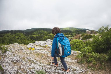 Çocuk bir dağ yolu boyunca yürür.. 