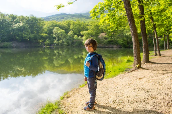 Chlapec s batohu na jezeře. — Stock fotografie