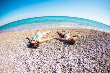 Annesi ile çocuk sahilde güneşlenmek.