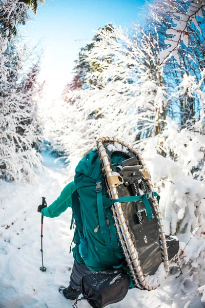 Kvinna med ryggsäck och snöskor i vinter fjällen. — Stockfoto