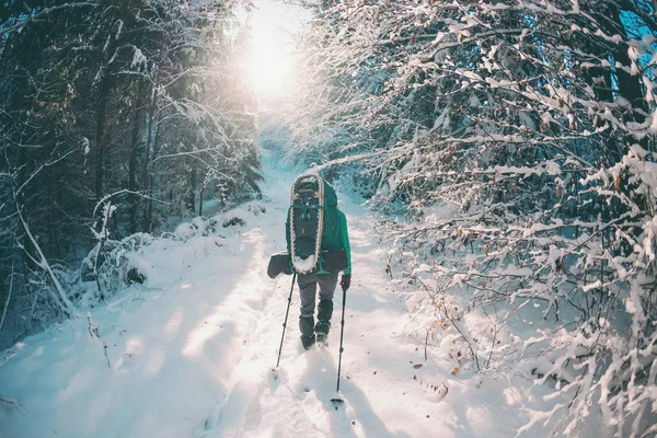 Mujer con mochila y raquetas de nieve en las montañas de invierno . —  Fotos de Stock