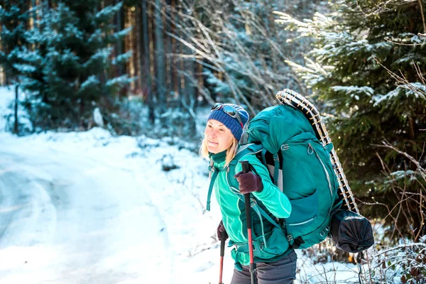 Kobieta z plecaka i wypożyczalnia rakiet śnieżnych w górach zimowych. — Zdjęcie stockowe