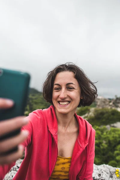 Kobieta bierze selfie na szczycie góry. — Zdjęcie stockowe