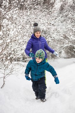 Çocuk karlı bir yolda annesinden kaçıyor..