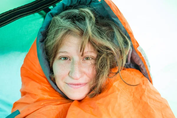 Ein Mädchen guckt aus einem Schlafsack. — Stockfoto