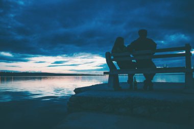 Sevgililer gün batımında sahilde şarap içerler..
