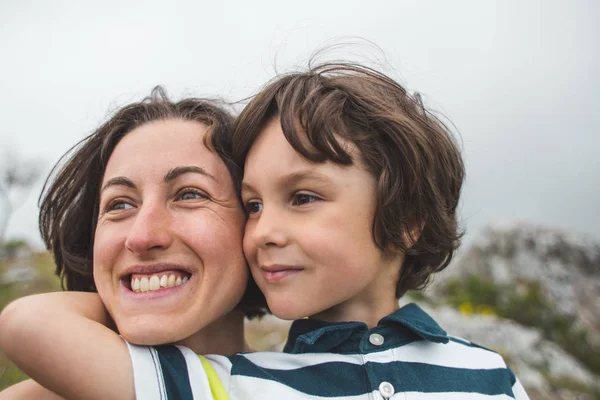 The boy hugs mom.