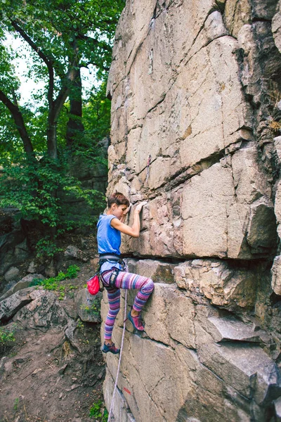 Dívka šplhá po žulovém kameni. — Stock fotografie