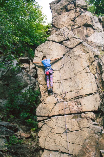 The girl climbs the granite rock. — Stock Photo, Image