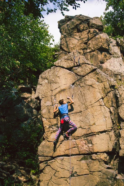 The girl climbs the granite rock. — Stock Photo, Image