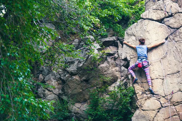 Das Mädchen erklettert den Granitfelsen. — Stockfoto