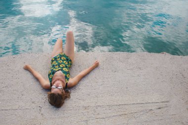 Bir kadın kumsalda güneşleniyor..