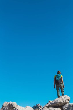 Gökyüzünün ve dağların arka planındaki kız.