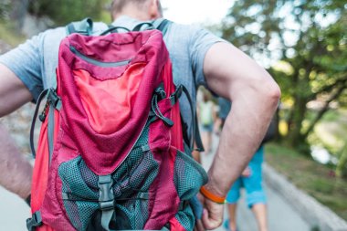 Sırt çantalı bir adam parkta yürüyor.. 