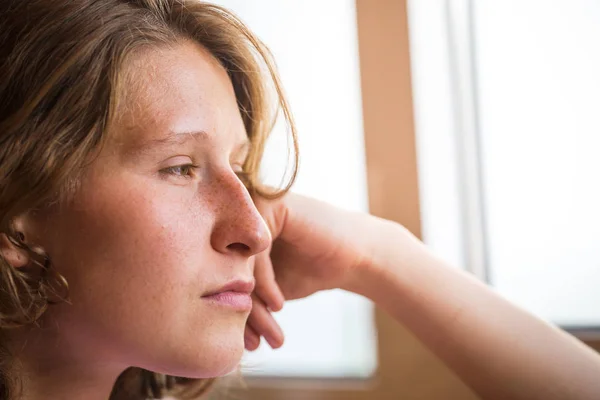 Portret van een vrouw in de buurt van het venster. — Stockfoto