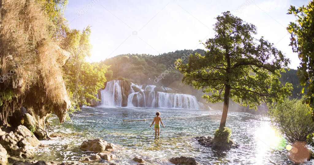 A man bathes in the falls of the national park of Croatia, Travel to beautiful places in Europe, Croatian waterfalls.