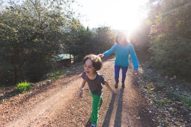 Bir kadın çocuğuyla orman yolunda koşar, çocuk annesinden kaçar, bir kadın oğluyla doğada vakit geçirir, parkta yürür..