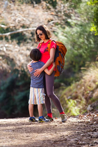 Niño Abraza Mamá Parque Una Mujer Con Una Mochila Camina — Foto de Stock