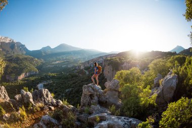 Sırt çantalı bir kadın dağın tepesinde durur ve bir dağ vadisinin güzelliğine hayran kalır, güzel yerlere seyahat eder, hedefe ulaşır, güzel manzara, Türkiye 'de seyahat eder..