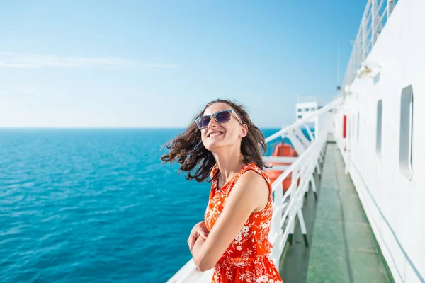 A woman is sailing on a cruise ship, a girl is standing near the fence on a ship and looking at the sea, traveling by ferry, a brunette in a summer dress admires the ocean.