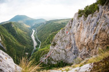 Dağlarda yüksek bir yer. Bir adam askı takıyor. Highline çizgide. Bir ip cambazı dengeyi yakalar. Eşitlik. Gergin bir durumda güven.