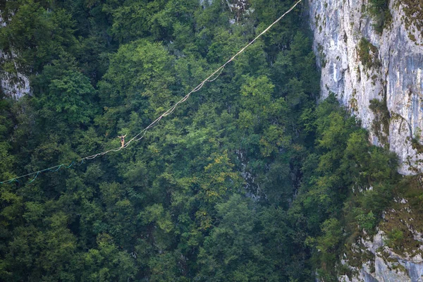 Dağlarda yüksek bir yer. Bir adam askı takıyor. Highline çizgide. Bir ip cambazı dengeyi yakalar. Eşitlik. Gergin bir durumda güven.