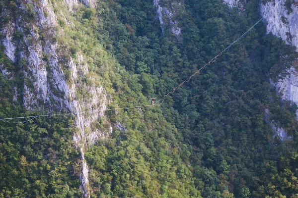 Bir Adam Gerilmiş Askı Boyunca Yürüyor Dağlarda Yüksek Bir Yer — Stok fotoğraf