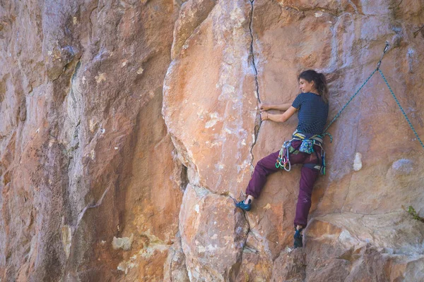A strong girl climbs a rock, Rock climbing in Turkey, Training endurance and strength, Woman in extreme sport, Rock climber is training in nature.
