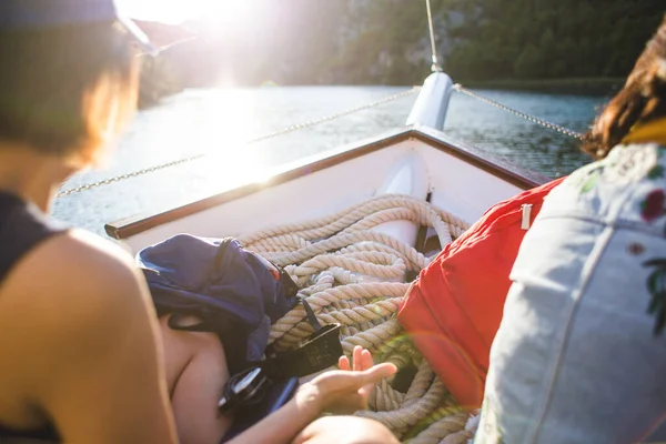 友達はボートで旅行するバックパックを背負った2人の少女が川の上のボートに乗って — ストック写真