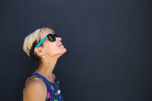 Una Chica Con Pelo Corto Levanta Contra Una Pared Gris —  Fotos de Stock