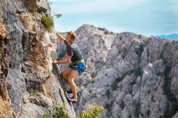 Dağların Denizin Arka Planında Bir Kaya Tırmanışçısı Bir Adam Kayaya — Stok fotoğraf
