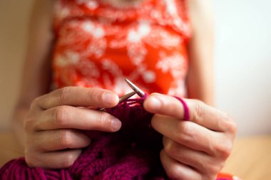 Kadın yatakta otururken örgü örüyor, kadın elleri şapka örüyor, kız karantina, el yapımı, favori ev hobisi sırasında yaratıcılıkla meşgul..