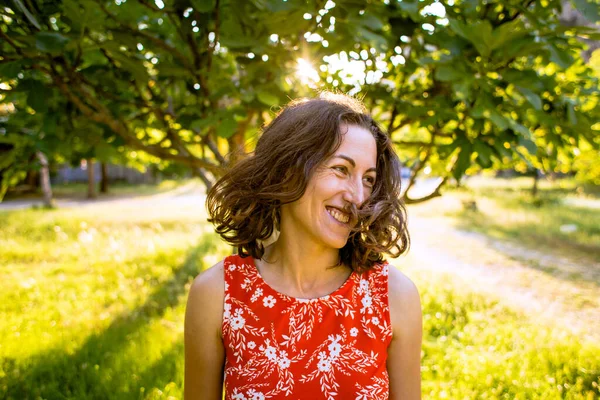 Portrait of a woman, the wind blows her hair, a brunette is resting in nature.