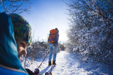 Bir kadın bir çocukla kızak çekiyor. Anne oğluyla karlı bir ormanda yürüyor. Parkta kış yürüyüşü. Oğlan bir kızağa biniyor. Çocuklarla kış aktiviteleri. Fisheye merceği.