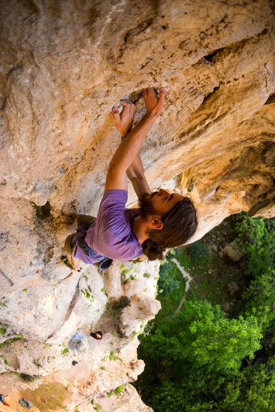 一个强壮的男人爬上悬崖 攀登者在自然的地形上克服了艰难的攀登道路 在土耳其攀岩 美丽的橙色岩石 — 图库照片