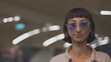 Metro istasyonunda gülümseyen güneş gözlüklü kız. Metrodaki kız..
