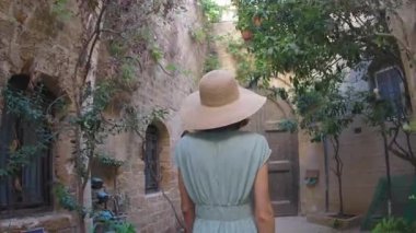 Elbiseli zarif bir kız Eski Şehir 'in dar sokaklarında yürüyor. Yaz seyahatleri ve maceralar.