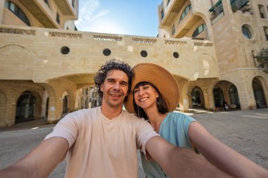 Güzel, birbirine aşık genç bir çift şehrin caddesinde dikilip selfie çekiyor ve yürüyüşün tadını çıkarıyor. Aşk ve ilişki.