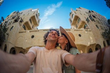 Güzel, birbirine aşık genç bir çift şehrin caddesinde durmuş selfie çekiyor ve öpüşüyorlar. Aşk ve ilişki.