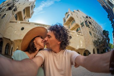 Güzel, birbirine aşık genç bir çift şehrin caddesinde durmuş selfie çekiyor ve öpüşüyorlar. Aşk ve ilişki.