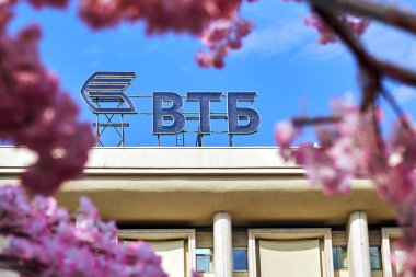Rusya, Moskova - 30 Nisan 2018. Moskova Caddesi üzerinde dekoratif bir kiraz ağacının çiçekleri ile görülen Vtb banka logosu