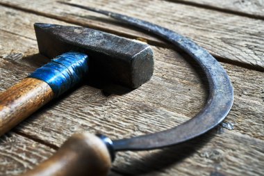Eski çekiç ve ahşap tahta arka plan üzerinde yalan orak