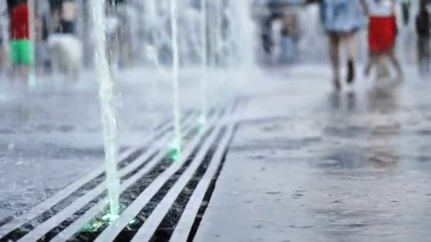 莫斯科地板喷泉的水喷雾慢动作拍摄和年轻人奔跑和跳跃横跨它享受生活在夏天温暖的晚上 — 图库视频影像