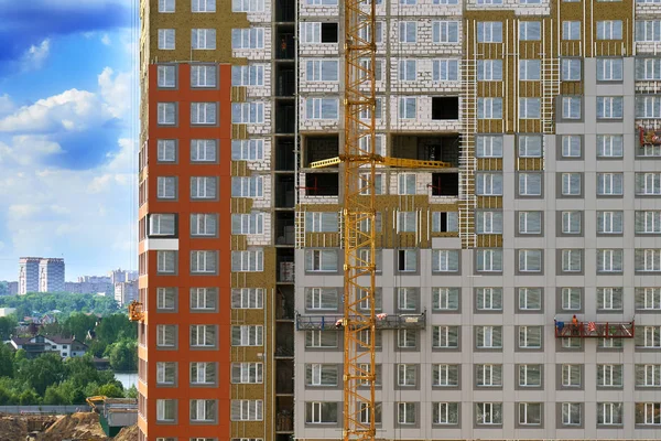 Fal az épület építési bölcsők, az épület mögött egy gyönyörű városra néző munkavállalók építés alatt — Stock Fotó