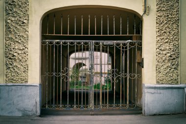 Archway of an old Moscow building closed by lattice gates clipart