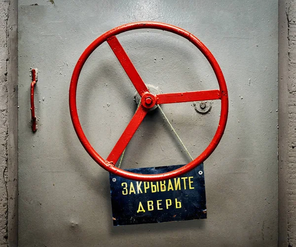 装甲地堡门与悬挂旧苏联破旧的招牌与俄罗斯关闭门警告 — 图库照片