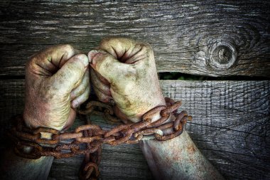 Kopya alanı ile ahşap arka plan üzerinde paslı zinciri ile zincirli yumruklarını içine sıktı güçlü erkek elleri kirli