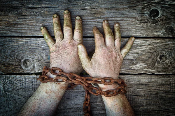 Homem Mãos Acorrentadas Com Corrente Enferrujada Fundo Madeira — Fotografia de Stock