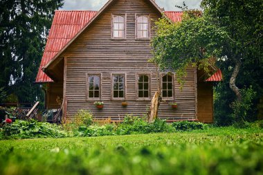 Kırmızı çatı ve yaz aylarında yeşil bahçe bir banliyö ev önden görünümü